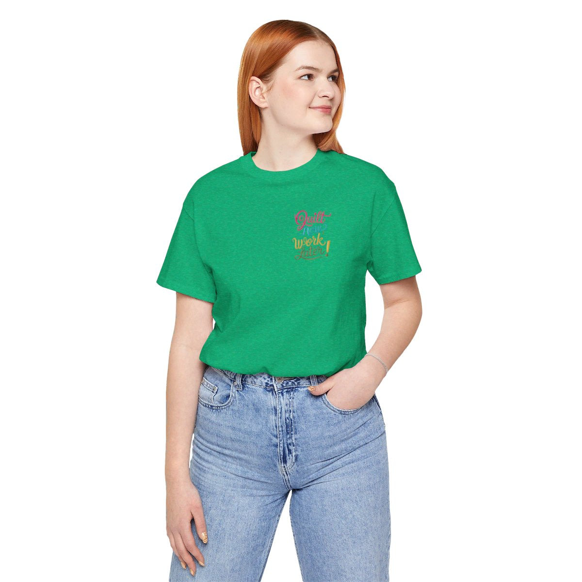 A Heather Kelly funny quilting T-shirt featuring bold, stylized text that reads "Quilt Now, Work Later" in various vibrant colors. The playful design captures the spirit of passionate quilters who prioritize their craft over other responsibilities.