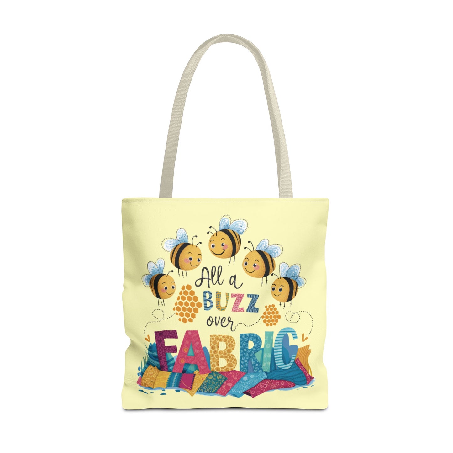 A light yellow quilting tote bag with a delightful quilting theme. Get ready to be all a buzz with excitement over your fabric stash! This playful "All a Buzz Over Fabric" 18" x 18" tote bag features adorable cartoon bees buzzing over a colorful pile of fabric, capturing the joy every quilter and sewer feels when surrounded by fabric goodness. Available in both light blue and light yellow, this cheerful design is perfect for carrying your fabric finds, sewing supplies, or everyday essentials.
