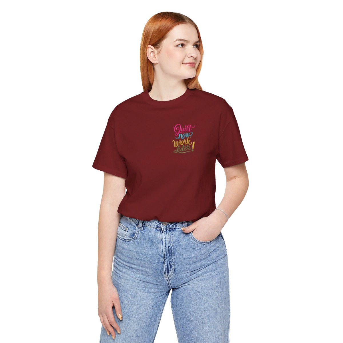 A Cardinal funny quilting T-shirt featuring bold, stylized text that reads "Quilt Now, Work Later" in various vibrant colors. The playful design captures the spirit of passionate quilters who prioritize their craft over other responsibilities.