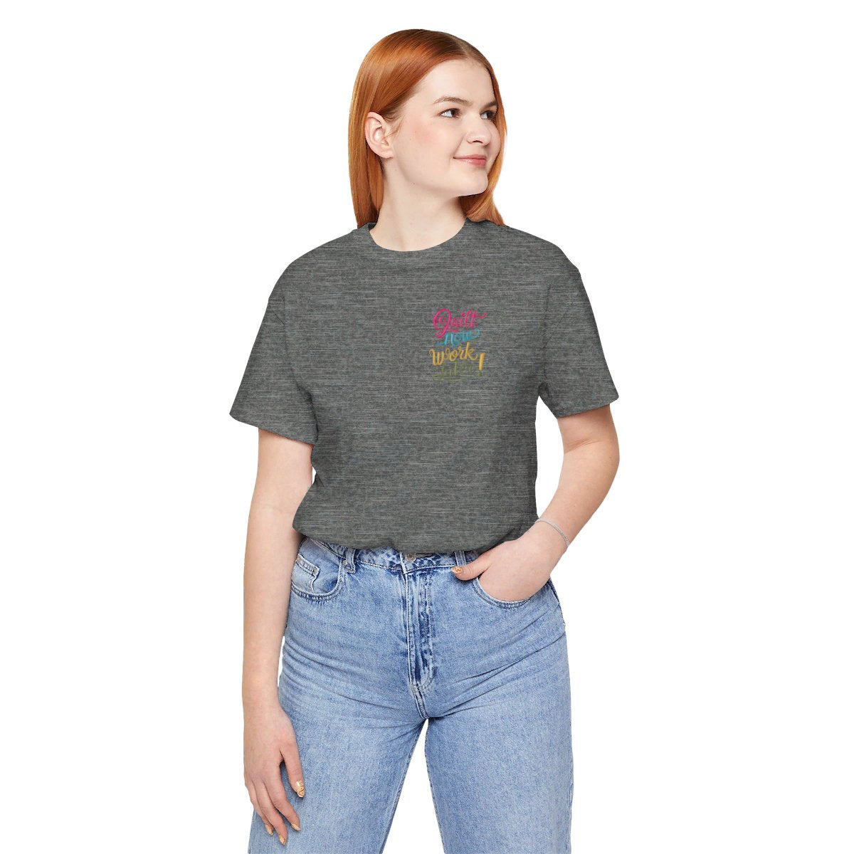 A Deep Heather funny quilting T-shirt featuring bold, stylized text that reads "Quilt Now, Work Later" in various vibrant colors. The playful design captures the spirit of passionate quilters who prioritize their craft over other responsibilities.