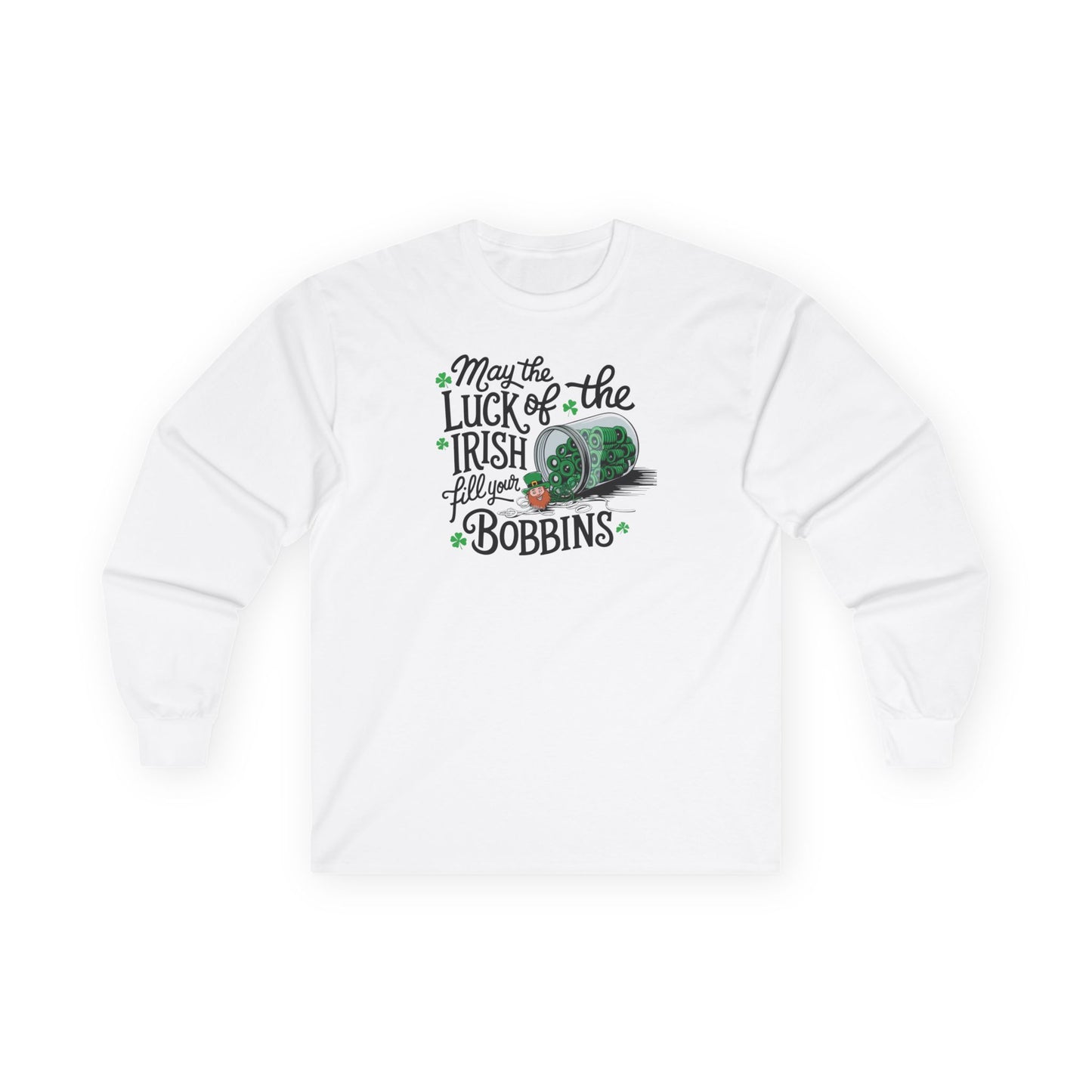 A White long-sleeve t-shirt featuring a festive design with shamrocks, a spool of green thread, and the phrase 'May the Luck of the Irish Fill Your Bobbins,' perfect for quilters celebrating St. Patrick’s Day.