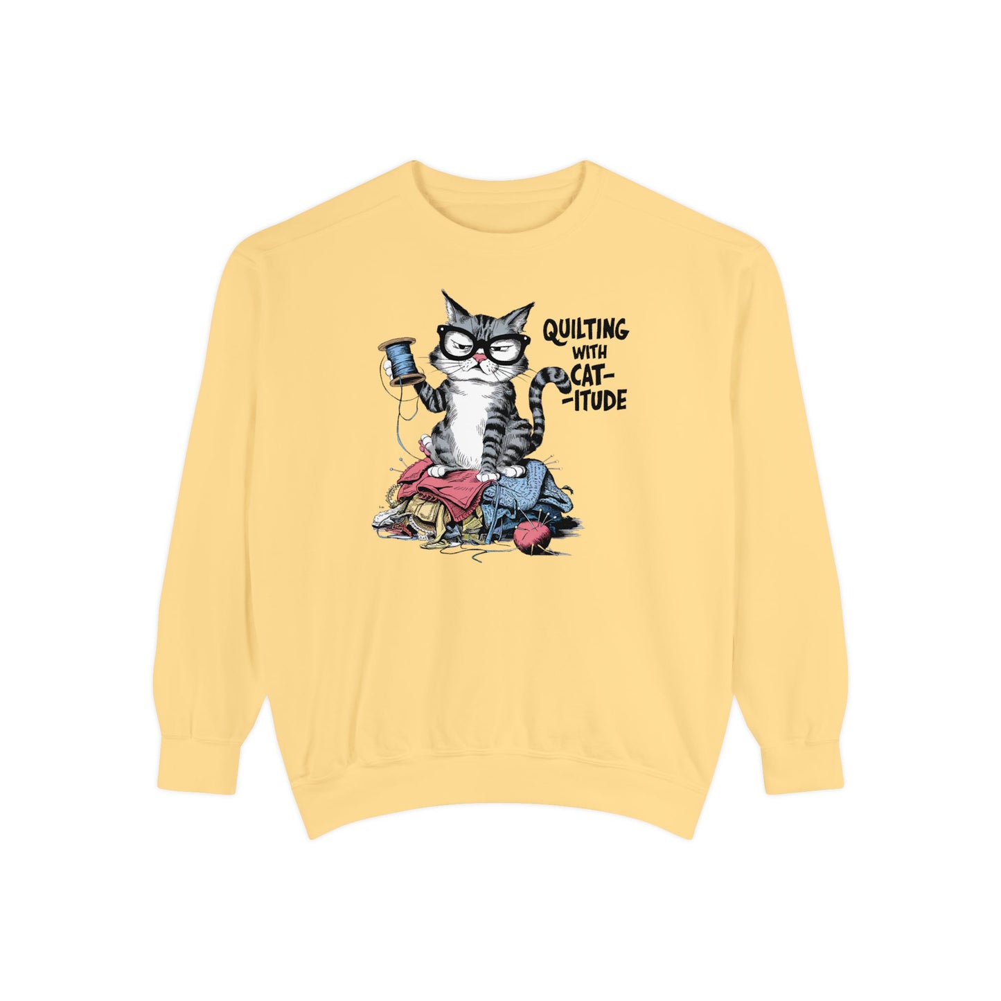 A Butter sweatshirt featuring a sassy cartoon cat sitting on a pile of colorful fabric, holding a spool of thread, with the phrase 'Quilting with Cat-itude,' perfect for quilters and cat lovers.