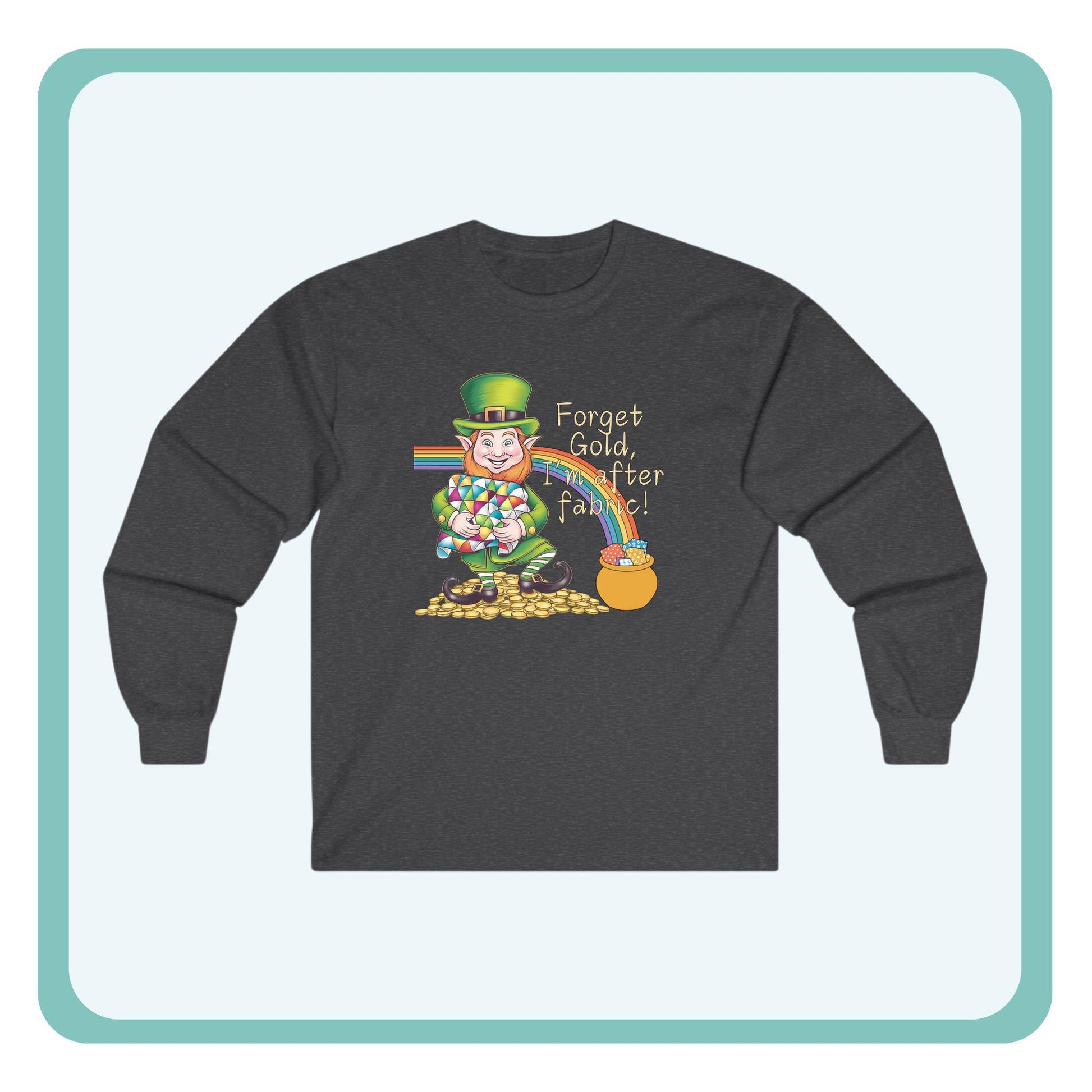 A long-sleeve t-shirt featuring a cheerful leprechaun holding a quilt, sitting on gold coins, with a rainbow leading to a fabric-filled pot and the phrase 'Forget Gold, I’m After Fabric!' Perfect for quilters celebrating St. Patrick’s Day.