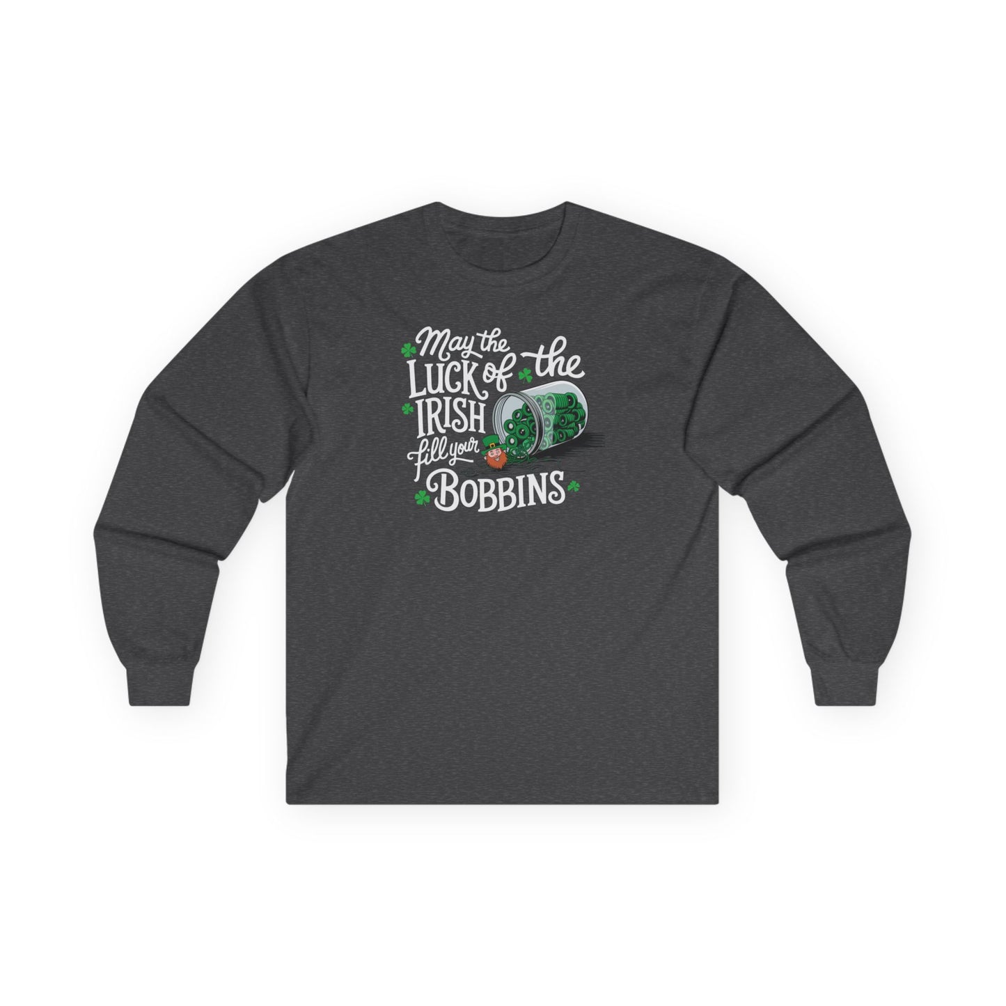 A Dark Heather long-sleeve t-shirt featuring a festive design with shamrocks, a spool of green thread, and the phrase 'May the Luck of the Irish Fill Your Bobbins,' perfect for quilters celebrating St. Patrick’s Day.