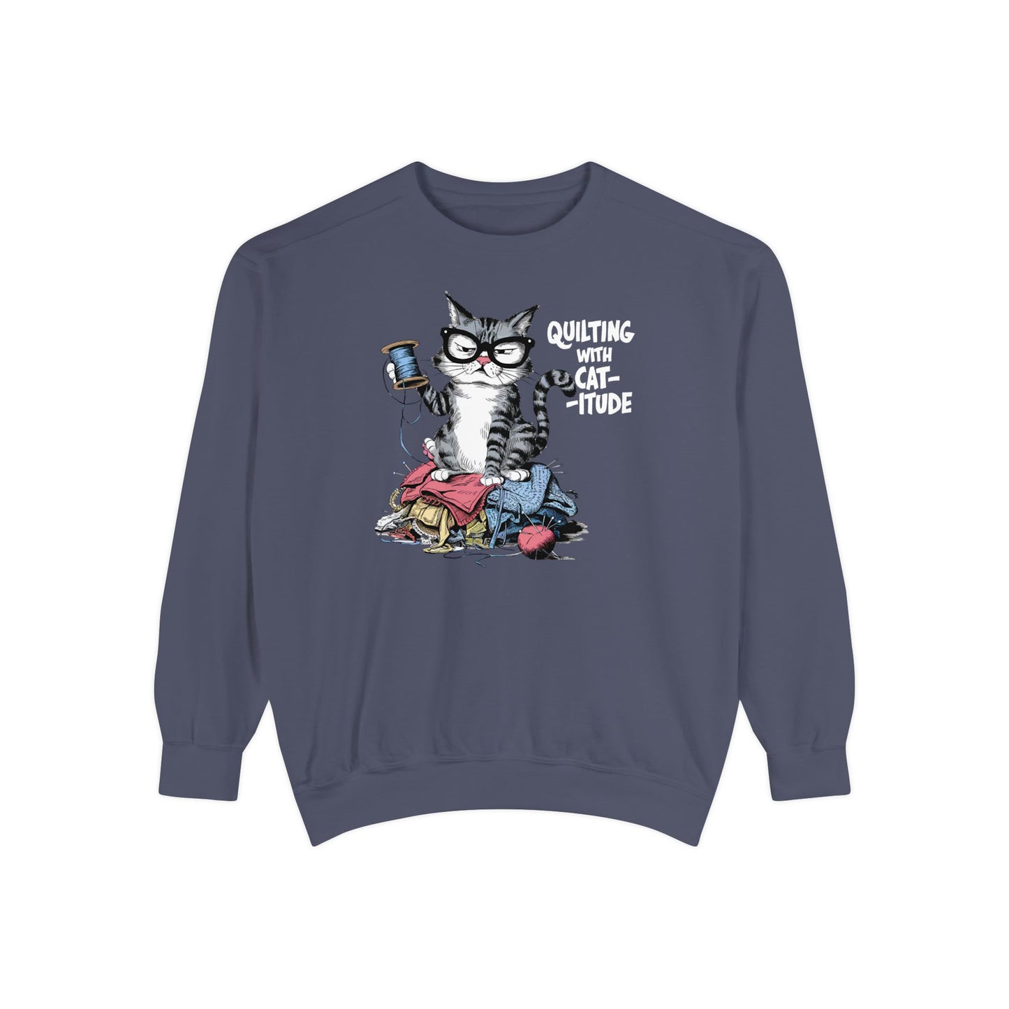 A Denim sweatshirt featuring a sassy cartoon cat sitting on a pile of colorful fabric, holding a spool of thread, with the phrase 'Quilting with Cat-itude,' perfect for quilters and cat lovers.