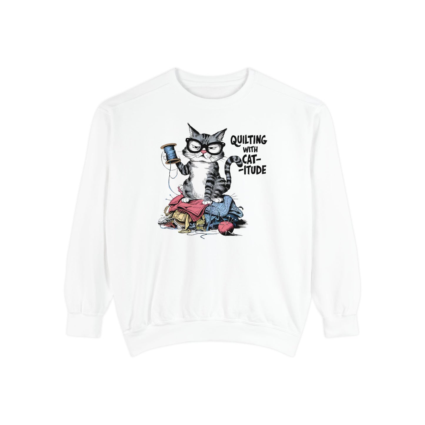 A White sweatshirt featuring a sassy cartoon cat sitting on a pile of colorful fabric, holding a spool of thread, with the phrase 'Quilting with Cat-itude,' perfect for quilters and cat lovers.