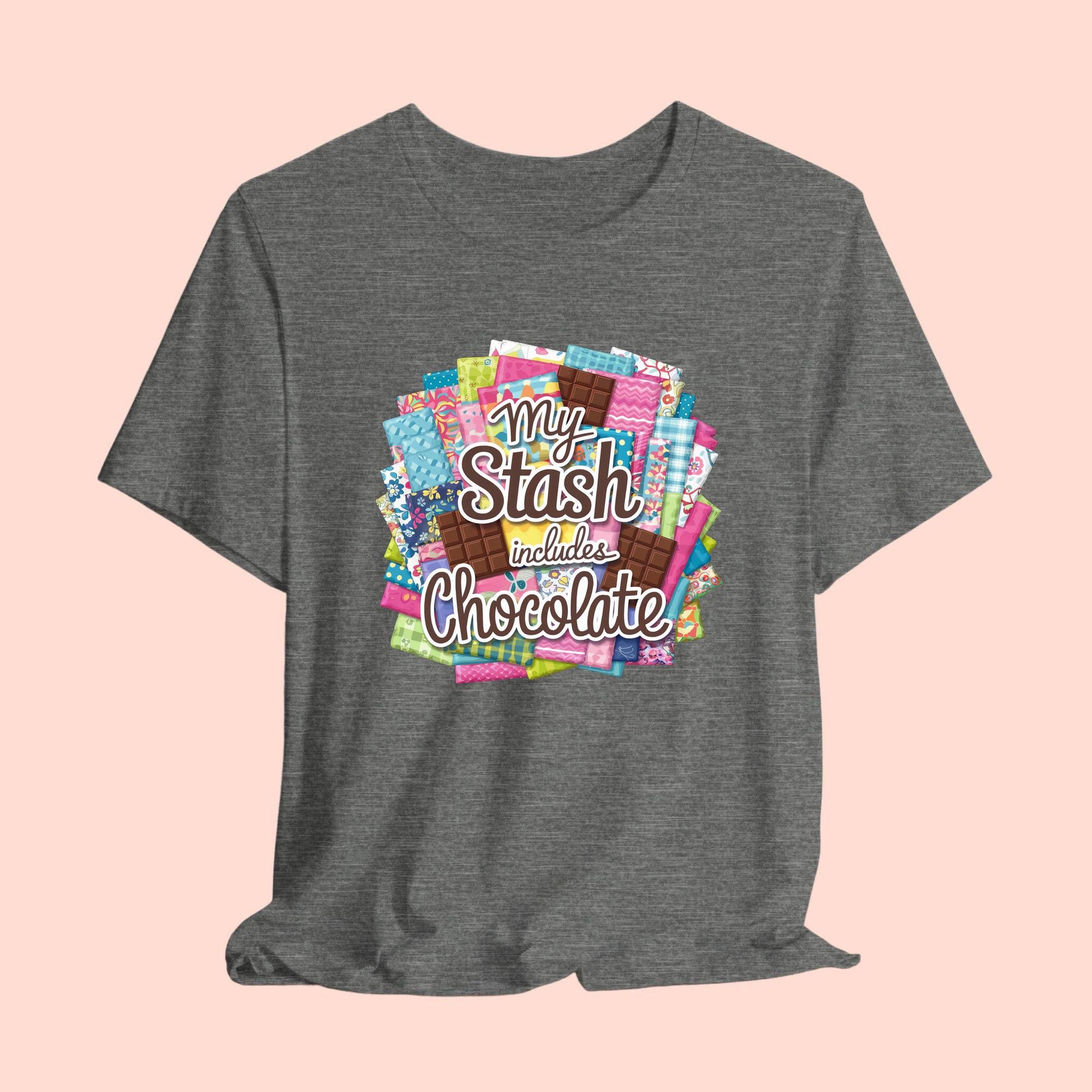 A t-shirt featuring a colorful design of a fabric stash mixed with chocolate bars and the phrase 'My Stash Includes Chocolate,' perfect for quilters and chocolate lovers