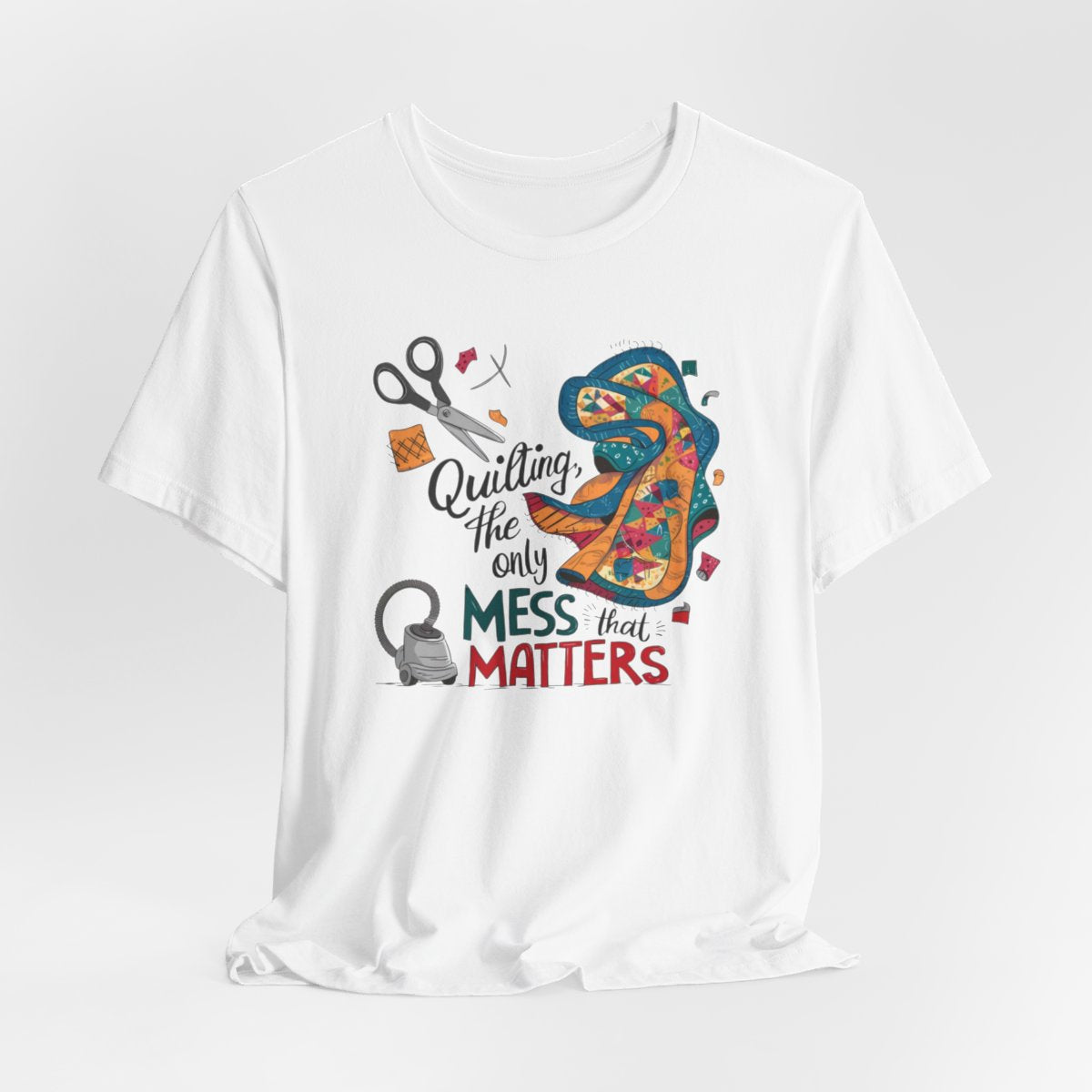 A White fun T-Shirt with the phrase Quilting, the Only Mess that Matters and illustrations of fabric scraps, scissors, and a vacuum cleaner. Colorful quilt patterns swirl around the text, creating a playful and relatable design for quilting enthusiasts.