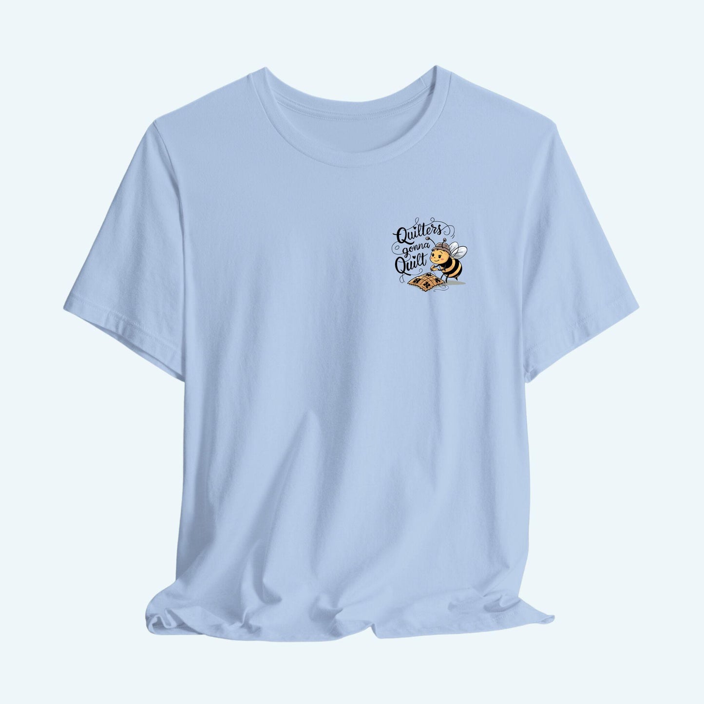 A funny quilting T-shirt design featuring a cartoon bee working on a quilt with the text "Quilters Gonna Quilt". The whimsical illustration and bold lettering capture the determination and passion of dedicated quilters.