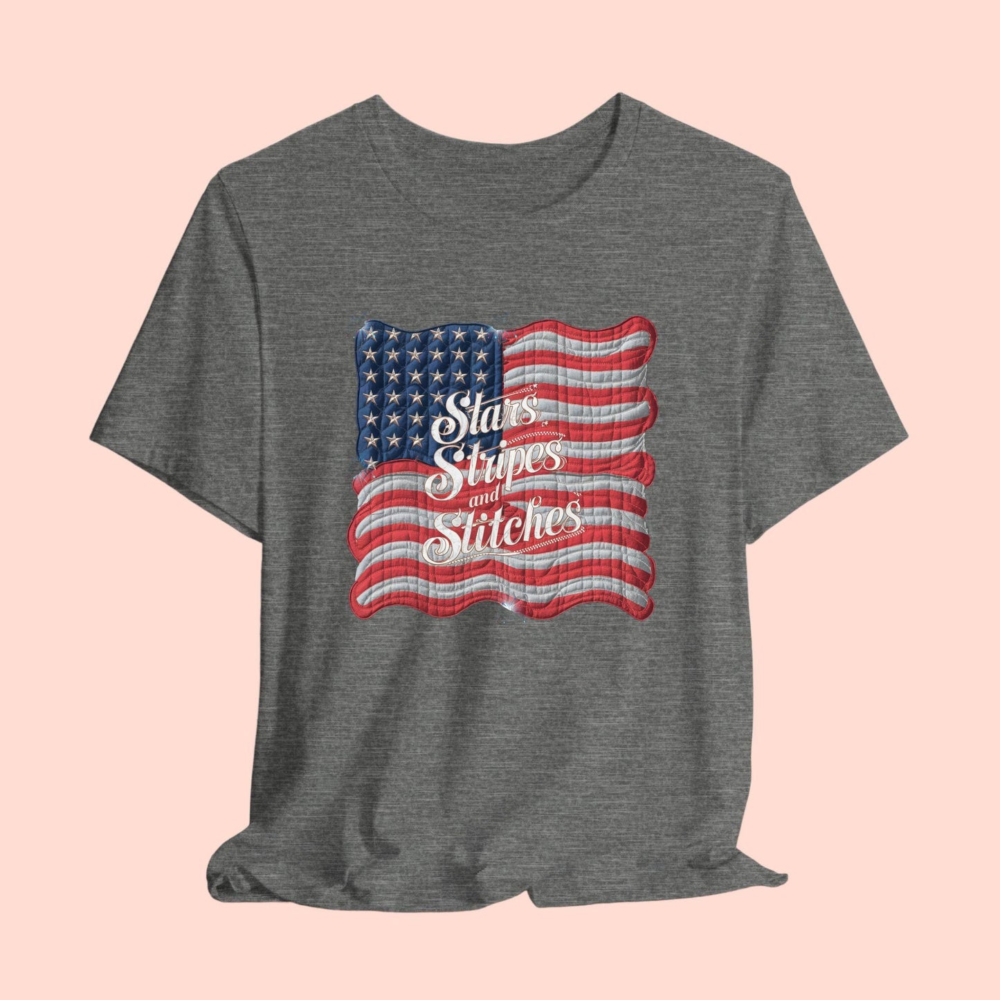 A T-shirt featuring quilted American flag design with text "Stars Stripes and Stitches" overlaid in stylized, patriotic font. Fireworks accent the corners.