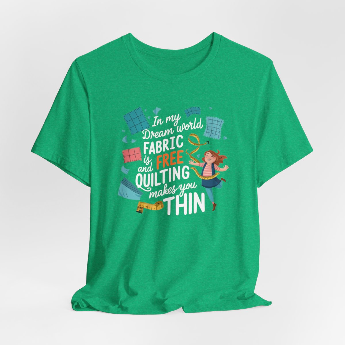 A Heather Kelly funny quilting T-Shirt with the phrase Fabric is Free and Quilting Makes You Thin in a fun font with a cheerful quilter jumping for joy