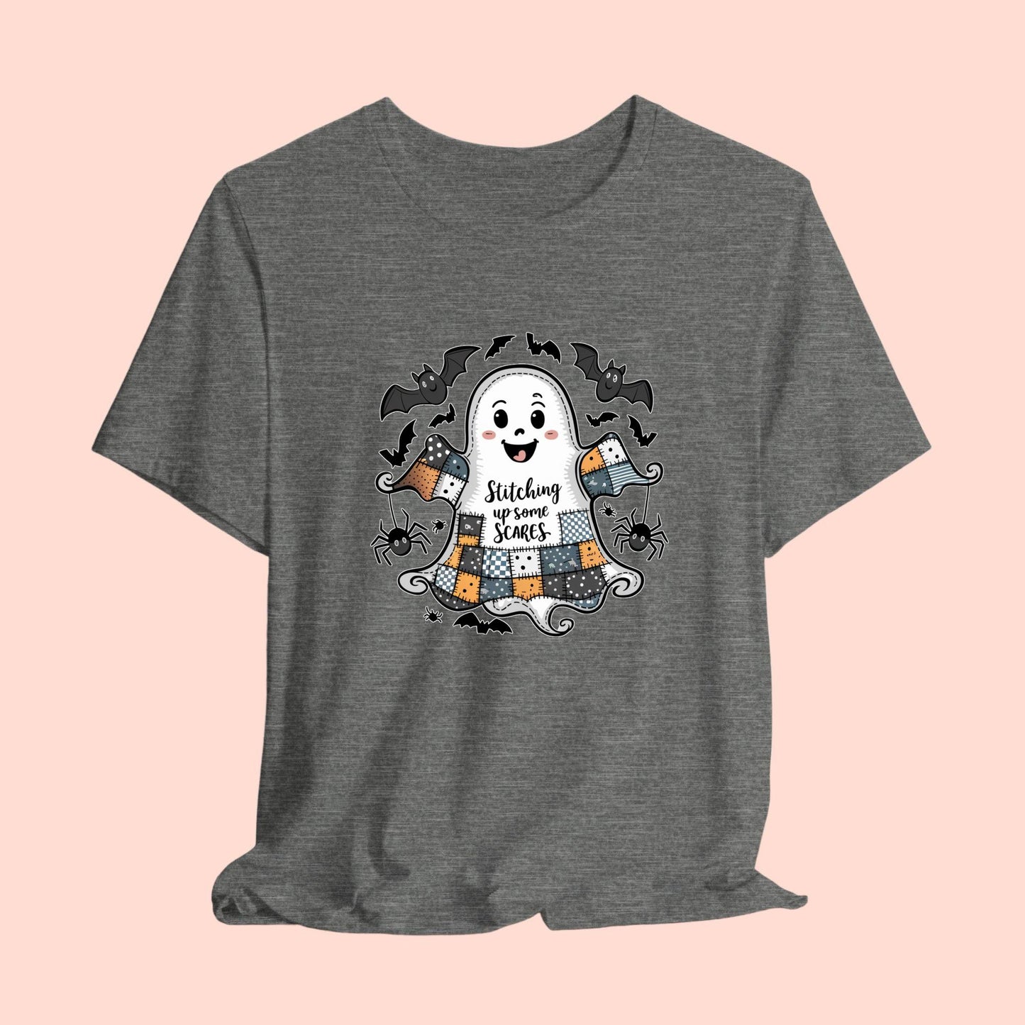 A Halloween Quilting T-Shirt featuring a smiling ghost with quilted patchwork body. Halloween-themed quilt patterns. Cute bats and spiders around ghost. Text reads "Stitching up some Scares". Ideal for quilters who enjoy Halloween themes.