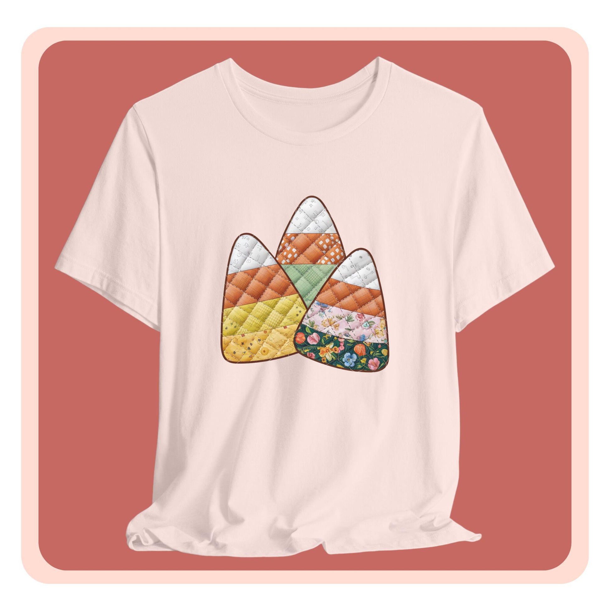 A Halloween Quilting T-Shirt featuring three large candy corn shapes made of quilted fabrics with various patterns. Each candy corn section features different quilting motifs in autumn colors. Playful take on Halloween candy and quilting craft.