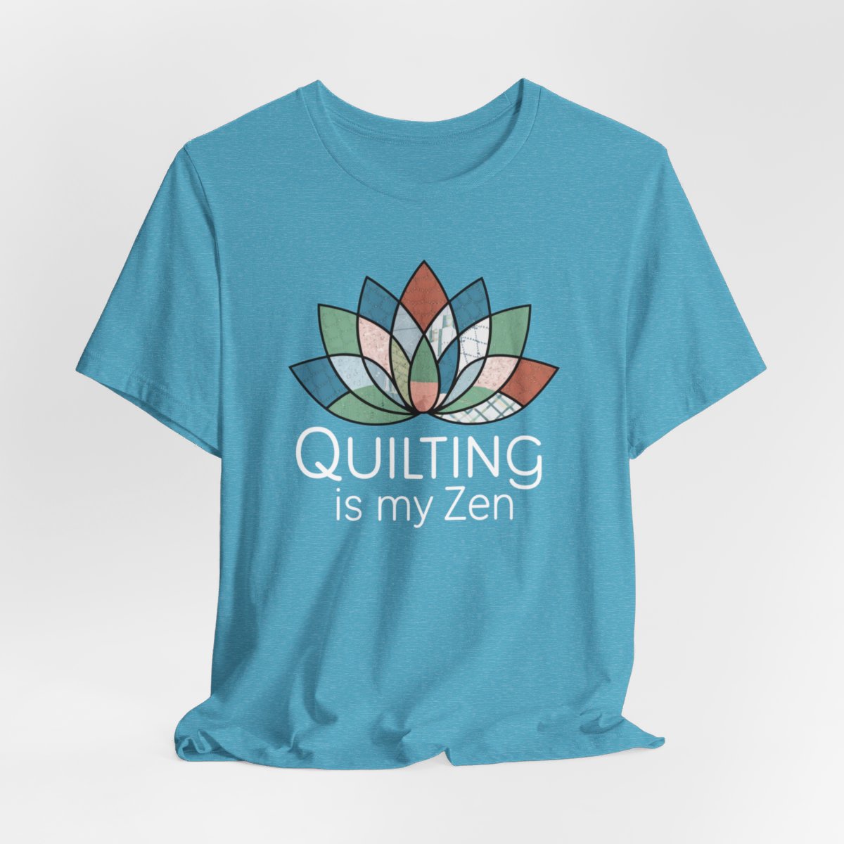 A Heather Aqua funny quilting T-Shirt with the phrase Quilting is my Zen on a quilting-themed t-shirt with a lotus flower design made of various quilt patterns and textures. 