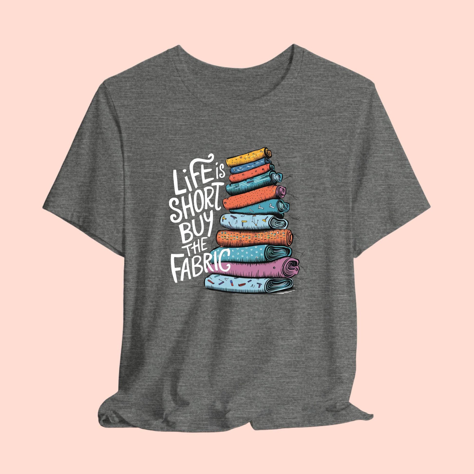 A fun T-Shirt with the phrase Life is Short, Buy the Fabric with the label 'Life is Short, Buy the Fabric' next to a graphic of a fun pile of fabric