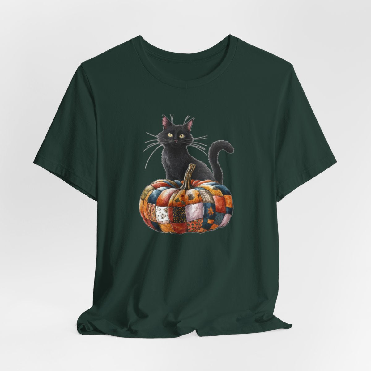 A Forest Halloween Quilting T-Shirt featuring a black cat sitting on colorful patchwork quilt pumpkin. Cat has yellow eyes and long whiskers. Pumpkin features various quilt patterns in autumn colors. Halloween-themed t-shirt design for quilting enthusiasts.