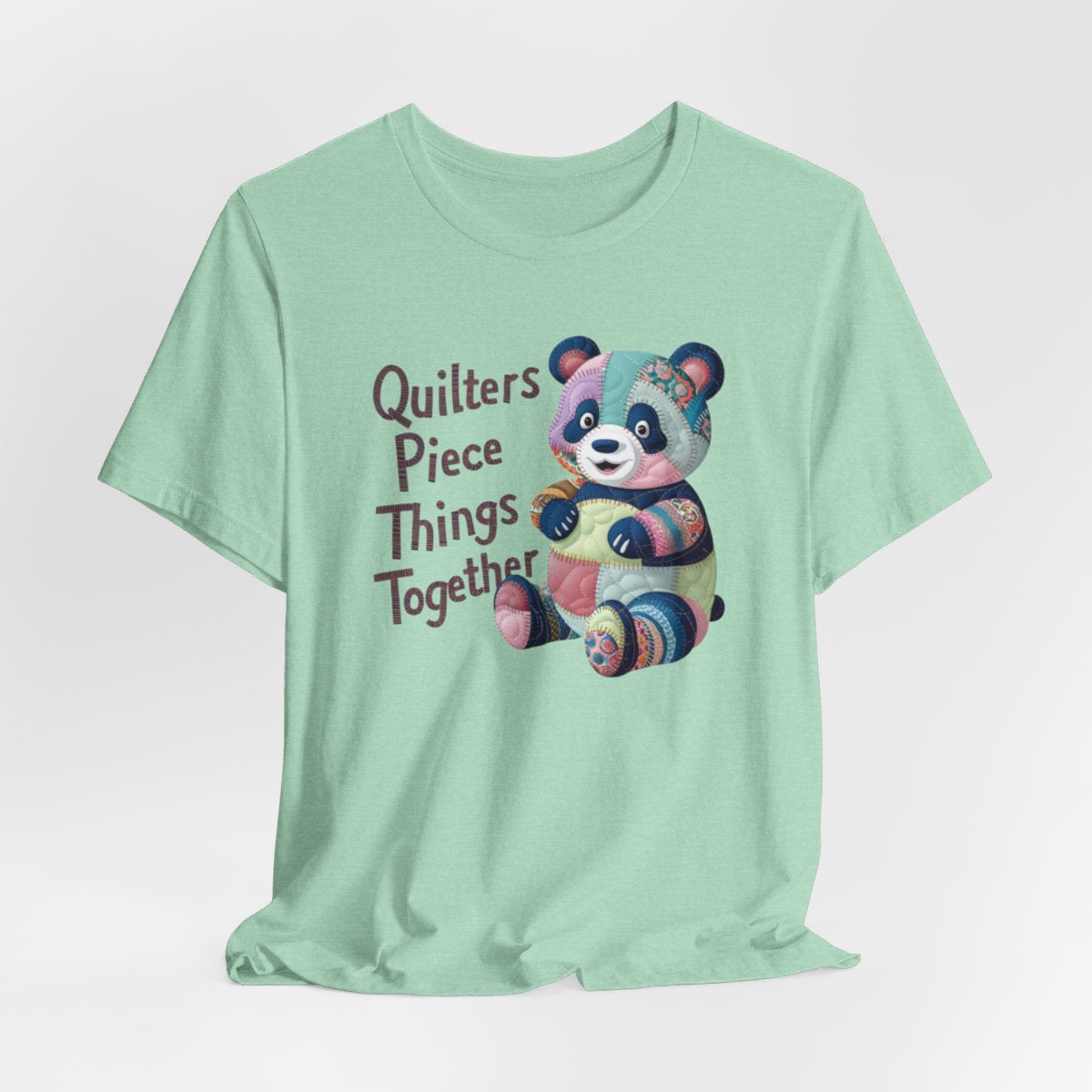 A Heather Mint fun T-Shirt with the phrase Quilters Piece Things Together with a patchwork panda design . The panda is made of colorful fabric scraps stitched together, creating a whimsical and crafty appearance. Perfect for quilting enthusiasts with a sense of humor.