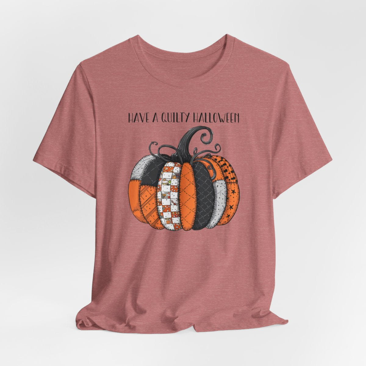 A Halloween Quilting T-Shirt featuring patchwork pumpkin with various quilt patterns. Mix of Halloween and traditional quilt motifs. Intricate stitching details. Text reads "Have a Quilty Halloween". Ideal for quilters who love Halloween.