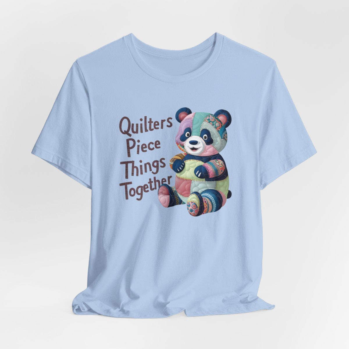 A Baby Blue fun T-Shirt with the phrase Quilters Piece Things Together with a patchwork panda design . The panda is made of colorful fabric scraps stitched together, creating a whimsical and crafty appearance. Perfect for quilting enthusiasts with a sense of humor.