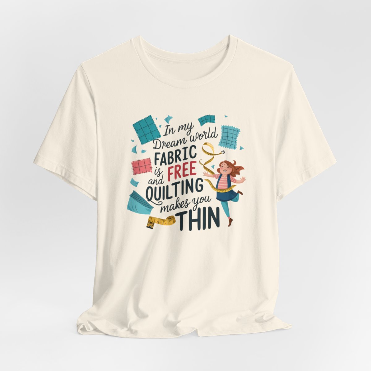 A Natural funny quilting T-Shirt with the phrase Fabric is Free and Quilting Makes You Thin in a fun font with a cheerful quilter jumping for joy