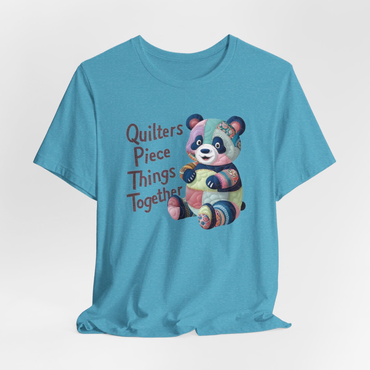 A Heather Aqua fun T-Shirt with the phrase Quilters Piece Things Together with a patchwork panda design . The panda is made of colorful fabric scraps stitched together, creating a whimsical and crafty appearance. Perfect for quilting enthusiasts with a sense of humor.