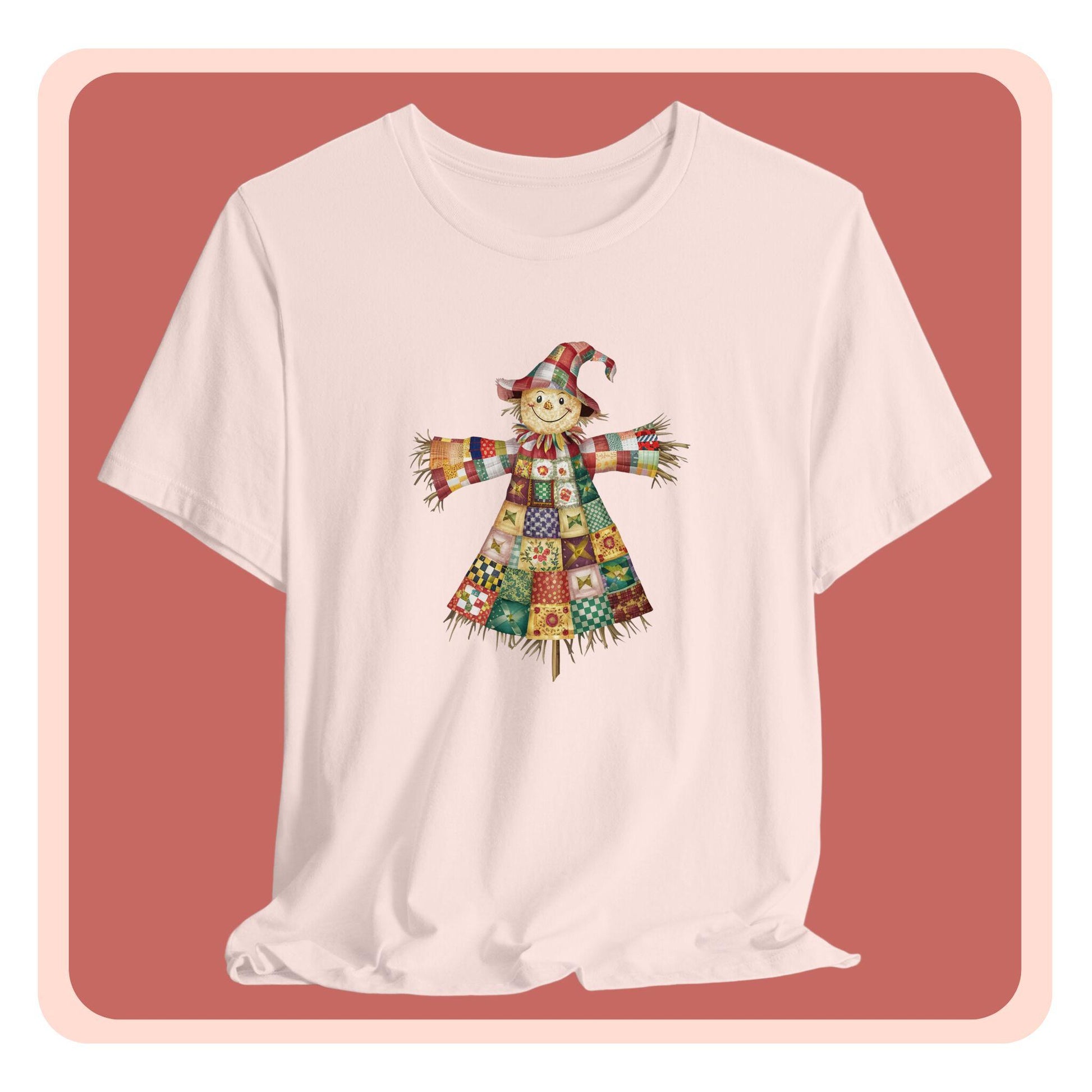 A thanksgiving  quilting t-shirt featuring a smiling scarecrow made entirely of colorful quilt patterns. Wearing a patchwork hat and clothes with various quilt designs. Straw details on hands and neck. Cheerful autumn-themed illustration celebrating quilting craft.