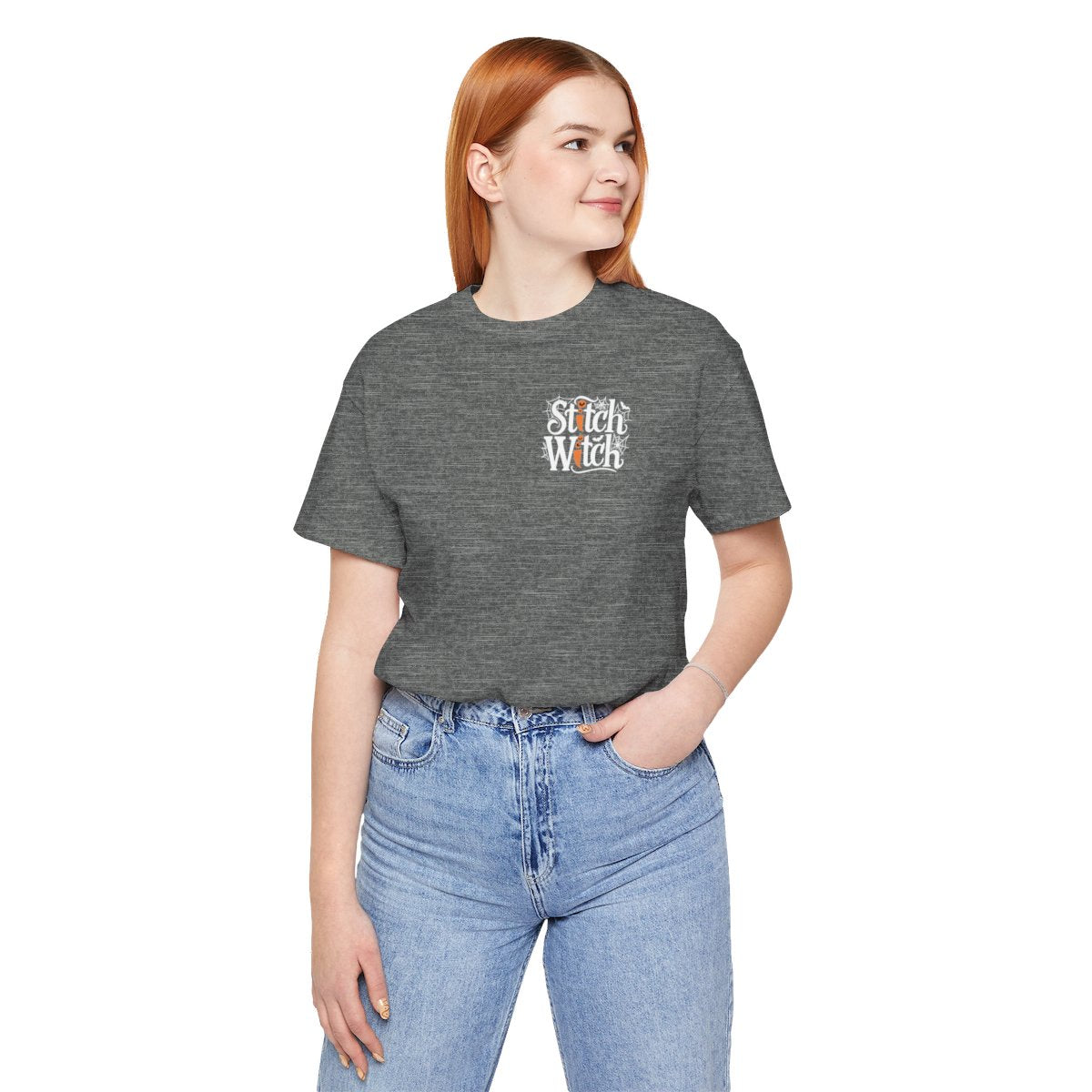 A Deep Heather Halloween Quilting T-Shirt featuring "Stitch Witch" text in Halloween-themed typography. Jack-o'-lanterns, spiderwebs, and bats decorate the letters. The "i" in "Stitch" resembles a sewing needle. Ideal for quilters who love Halloween.