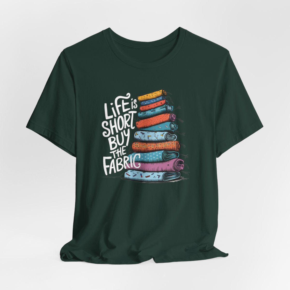 A Forest fun T-Shirt with the phrase Life is Short, Buy the Fabric with the label 'Life is Short, Buy the Fabric' next to a graphic of a fun pile of fabric