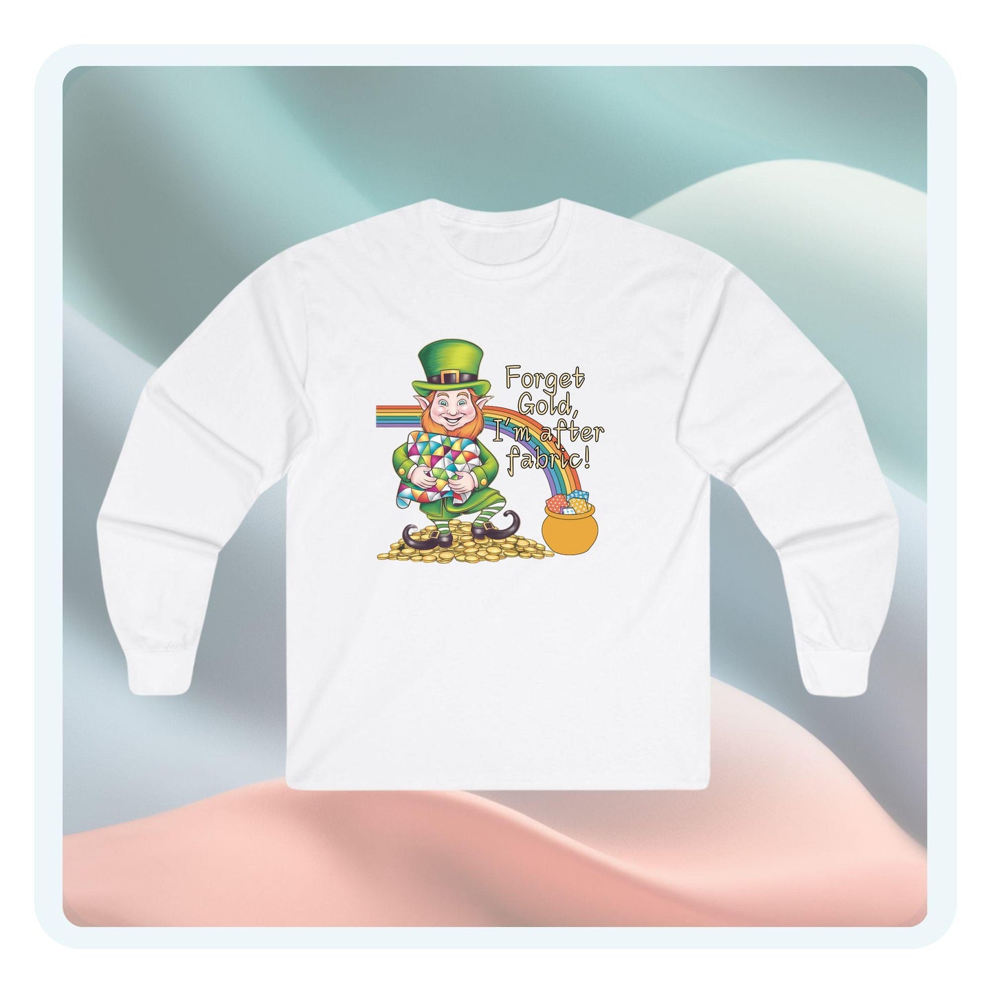 A long-sleeve t-shirt featuring a cheerful leprechaun holding a quilt, sitting on gold coins, with a rainbow leading to a fabric-filled pot and the phrase 'Forget Gold, I’m After Fabric!' Perfect for quilters celebrating St. Patrick’s Day.