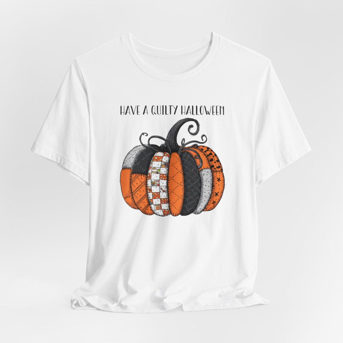 A White Halloween Quilting T-Shirt featuring patchwork pumpkin with various quilt patterns. Mix of Halloween and traditional quilt motifs. Intricate stitching details. Text reads "Have a Quilty Halloween". Ideal for quilters who love Halloween.