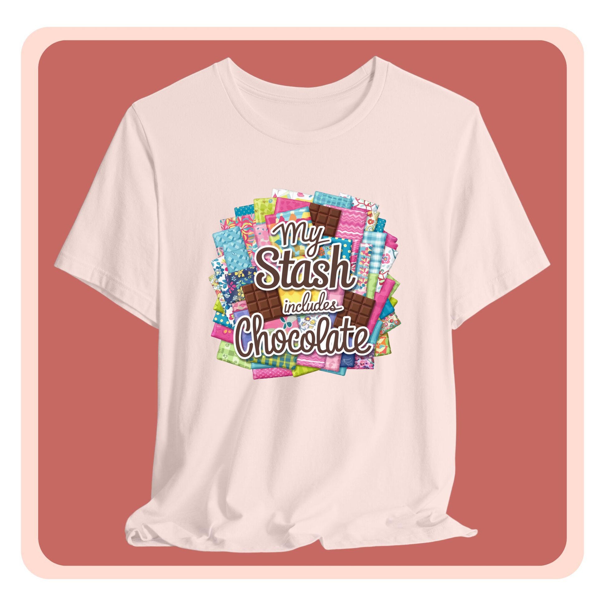 A t-shirt featuring a colorful design of a fabric stash mixed with chocolate bars and the phrase 'My Stash Includes Chocolate,' perfect for quilters and chocolate lovers