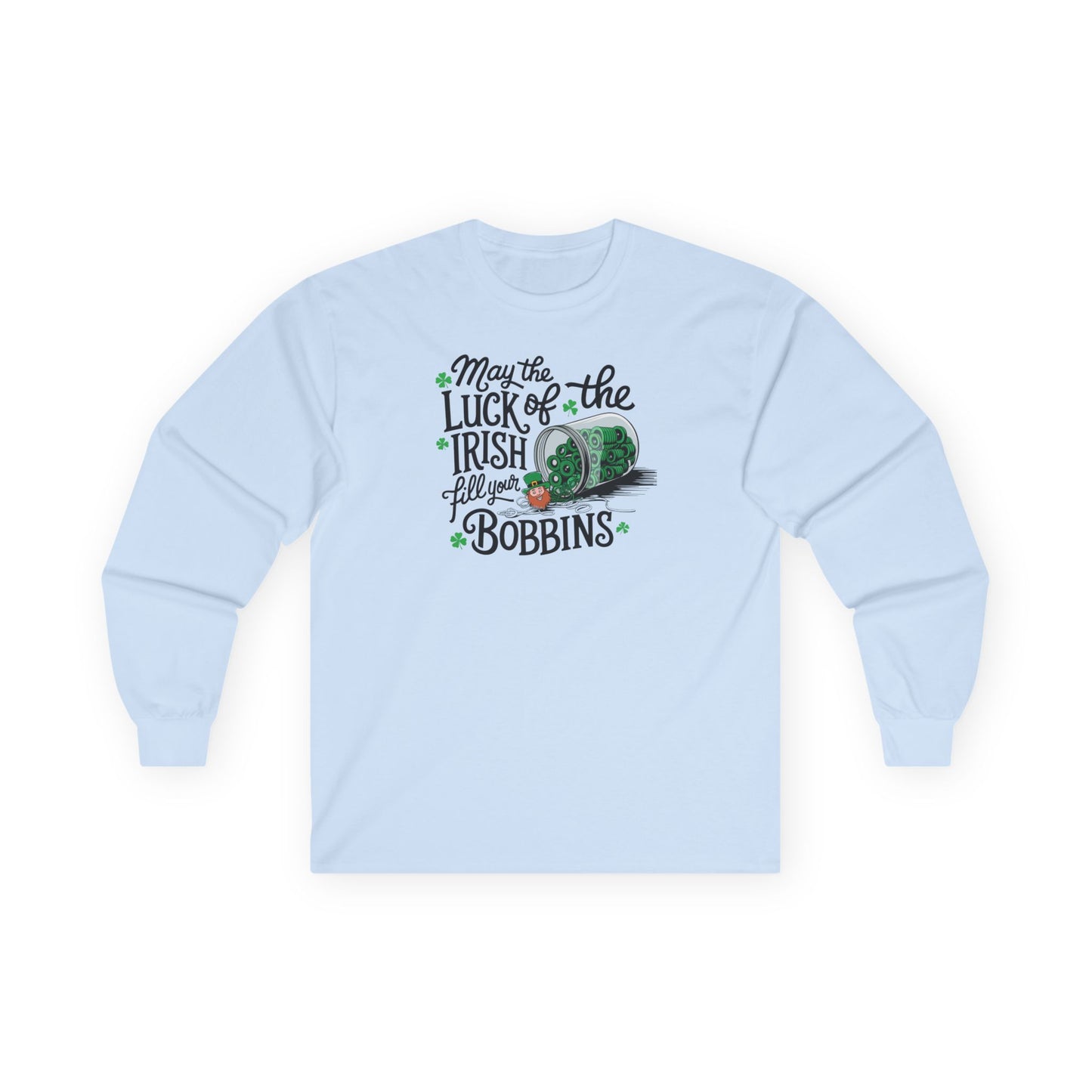 A Light Blue long-sleeve t-shirt featuring a festive design with shamrocks, a spool of green thread, and the phrase 'May the Luck of the Irish Fill Your Bobbins,' perfect for quilters celebrating St. Patrick’s Day.