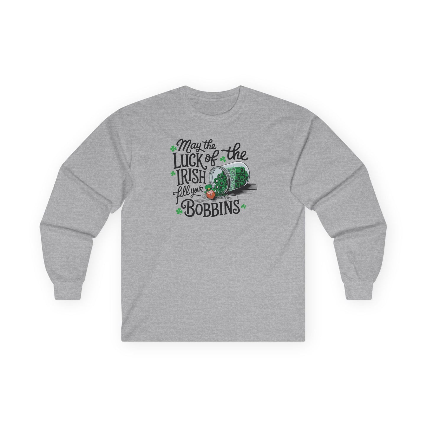 A Sport Grey long-sleeve t-shirt featuring a festive design with shamrocks, a spool of green thread, and the phrase 'May the Luck of the Irish Fill Your Bobbins,' perfect for quilters celebrating St. Patrick’s Day.