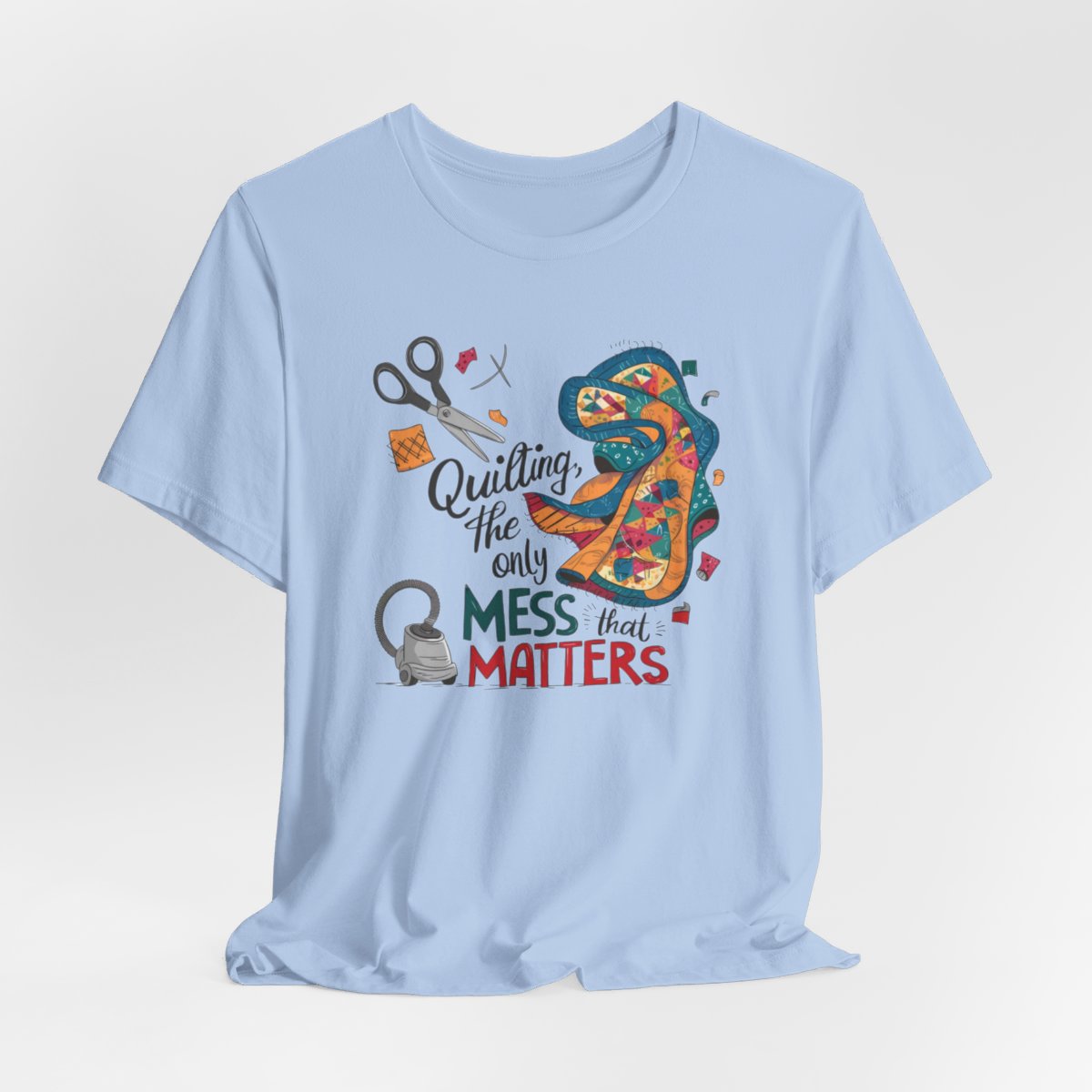 A Baby Blue fun T-Shirt with the phrase Quilting, the Only Mess that Matters and illustrations of fabric scraps, scissors, and a vacuum cleaner. Colorful quilt patterns swirl around the text, creating a playful and relatable design for quilting enthusiasts.