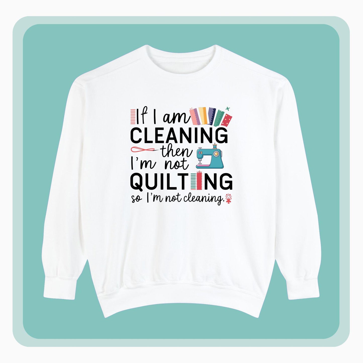 A funny Sweatshirt with the phrase If I am Cleaning then I'm not Quilting in a bold and cheerful font with images of quilting icons and supplies