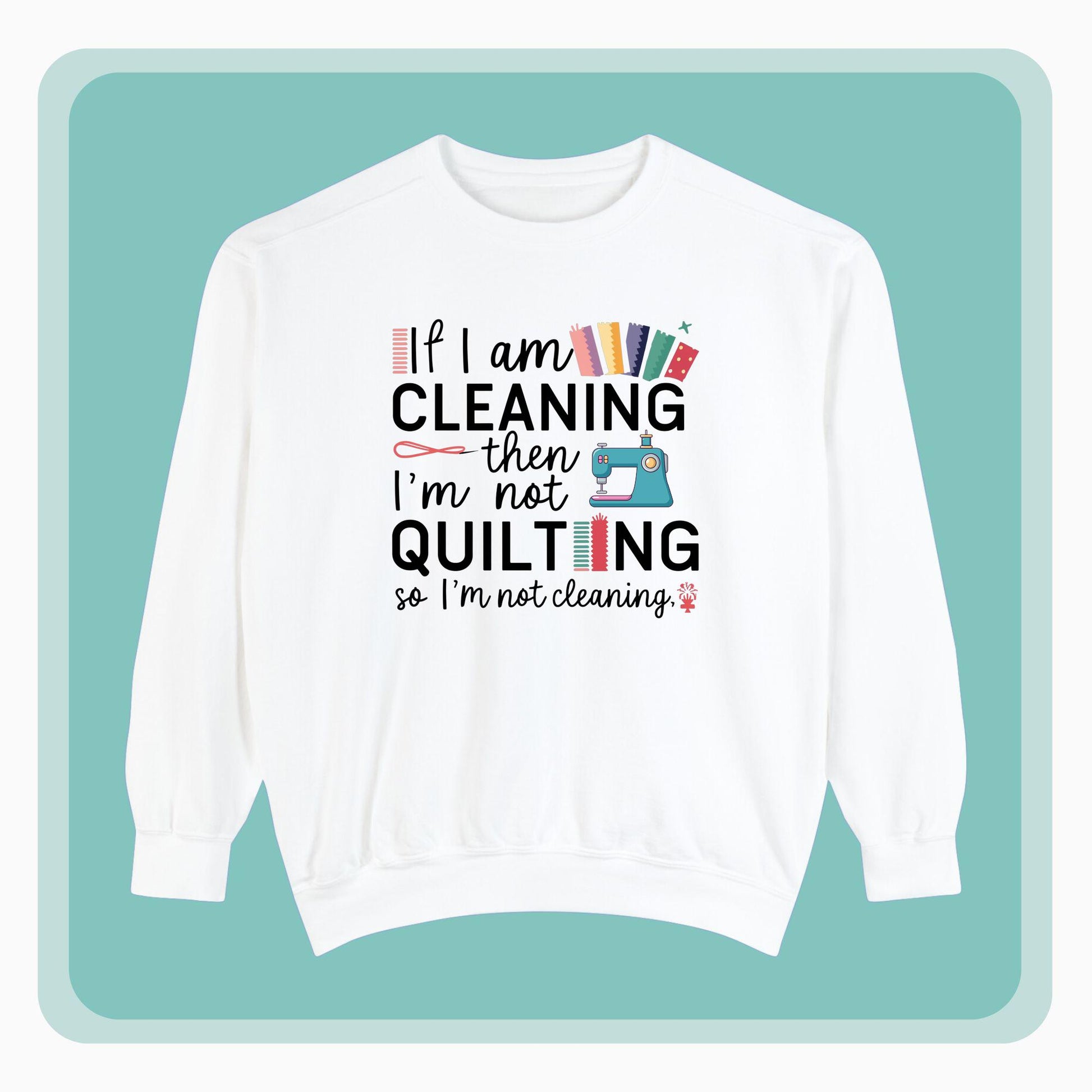 A funny Sweatshirt with the phrase If I am Cleaning then I'm not Quilting in a bold and cheerful font with images of quilting icons and supplies