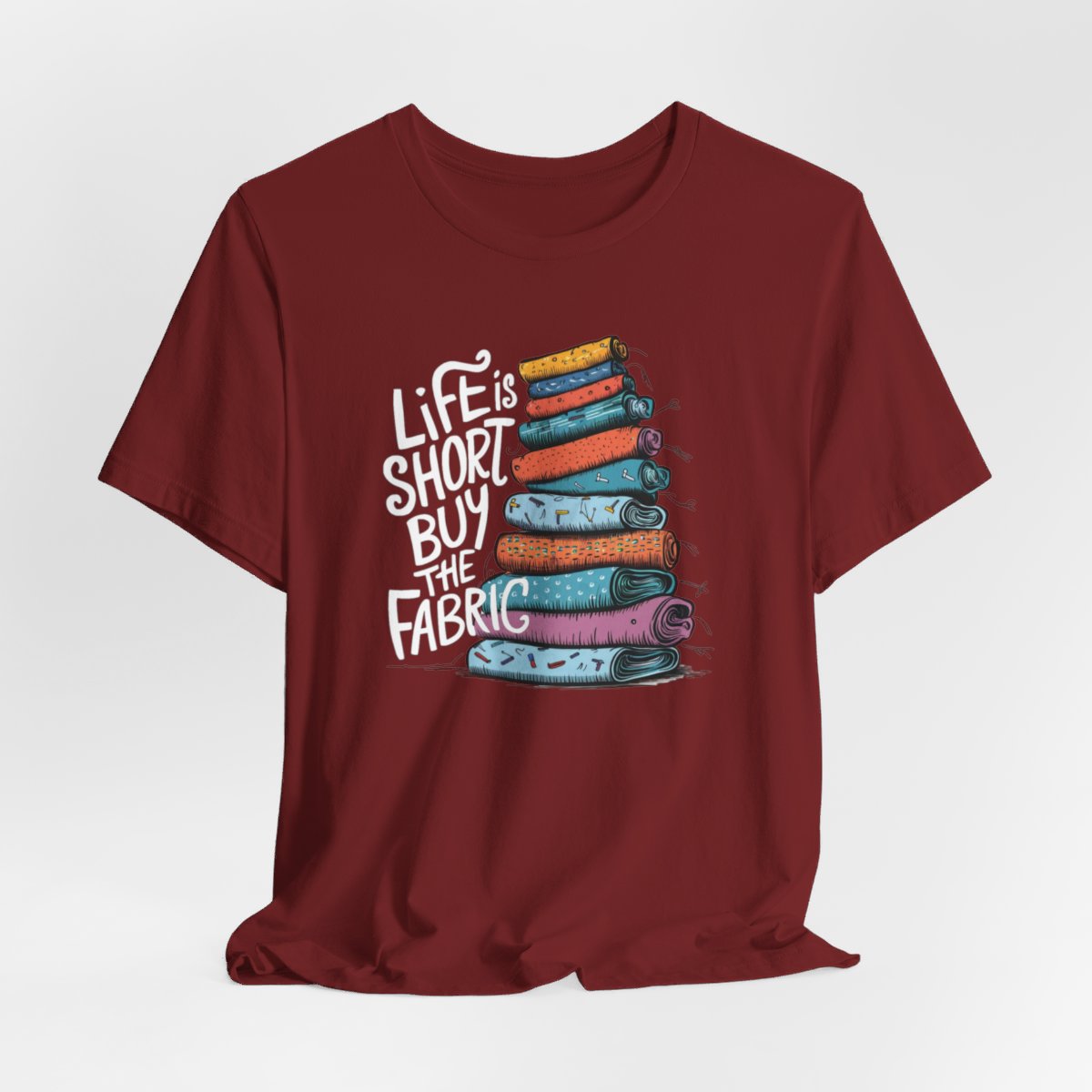 A Cardinal fun T-Shirt with the phrase Life is Short, Buy the Fabric with the label 'Life is Short, Buy the Fabric' next to a graphic of a fun pile of fabric