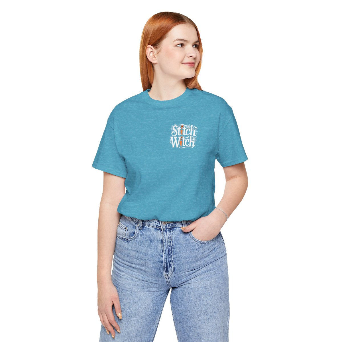 A Heather Aqua Halloween Quilting T-Shirt featuring "Stitch Witch" text in Halloween-themed typography. Jack-o'-lanterns, spiderwebs, and bats decorate the letters. The "i" in "Stitch" resembles a sewing needle. Ideal for quilters who love Halloween.