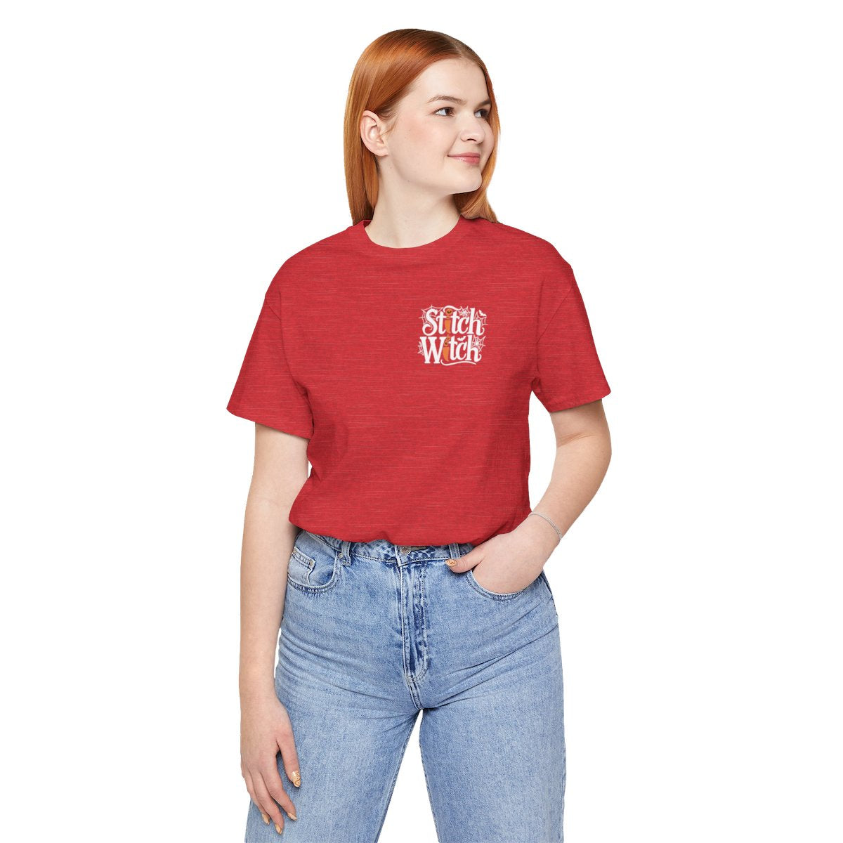 A Heather Red Halloween Quilting T-Shirt featuring "Stitch Witch" text in Halloween-themed typography. Jack-o'-lanterns, spiderwebs, and bats decorate the letters. The "i" in "Stitch" resembles a sewing needle. Ideal for quilters who love Halloween.