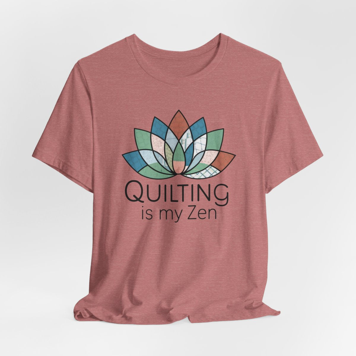 A Heather Mauve funny quilting T-Shirt with the phrase Quilting is my Zen on a quilting-themed t-shirt with a lotus flower design made of various quilt patterns and textures. 