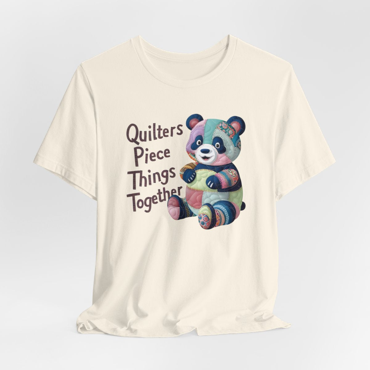 A Natural fun T-Shirt with the phrase Quilters Piece Things Together with a patchwork panda design . The panda is made of colorful fabric scraps stitched together, creating a whimsical and crafty appearance. Perfect for quilting enthusiasts with a sense of humor.