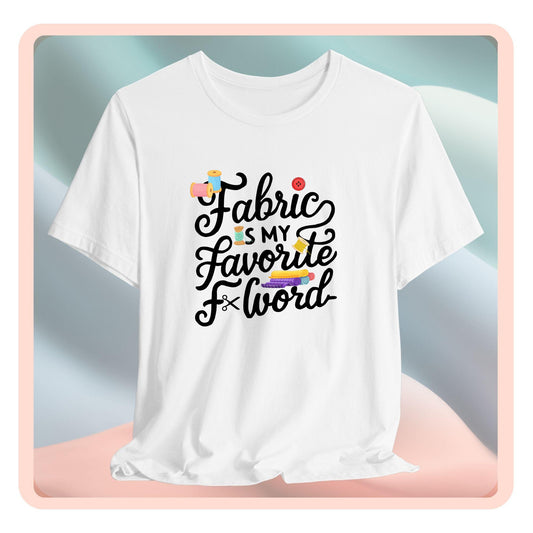 A T-Shirt with the phrase Fabric is My Favorite F-Word in a bold font with thread, buttons, and fabric bolts