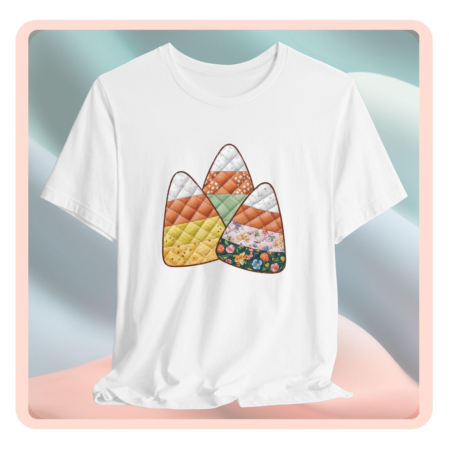 A Halloween Quilting T-Shirt featuring three large candy corn shapes made of quilted fabrics with various patterns. Each candy corn section features different quilting motifs in autumn colors. Playful take on Halloween candy and quilting craft.