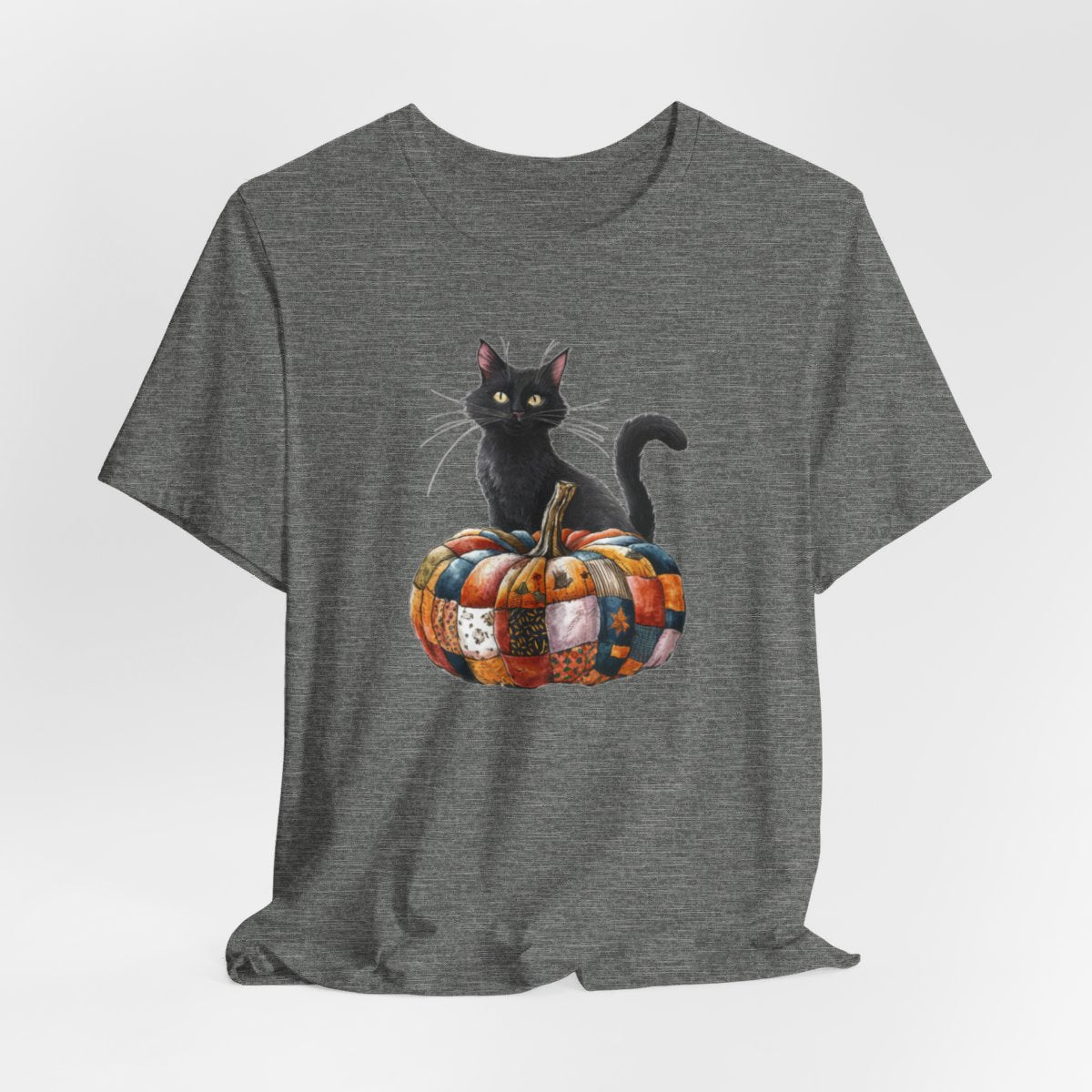 A Deep Heather Halloween Quilting T-Shirt featuring a black cat sitting on colorful patchwork quilt pumpkin. Cat has yellow eyes and long whiskers. Pumpkin features various quilt patterns in autumn colors. Halloween-themed t-shirt design for quilting enthusiasts.