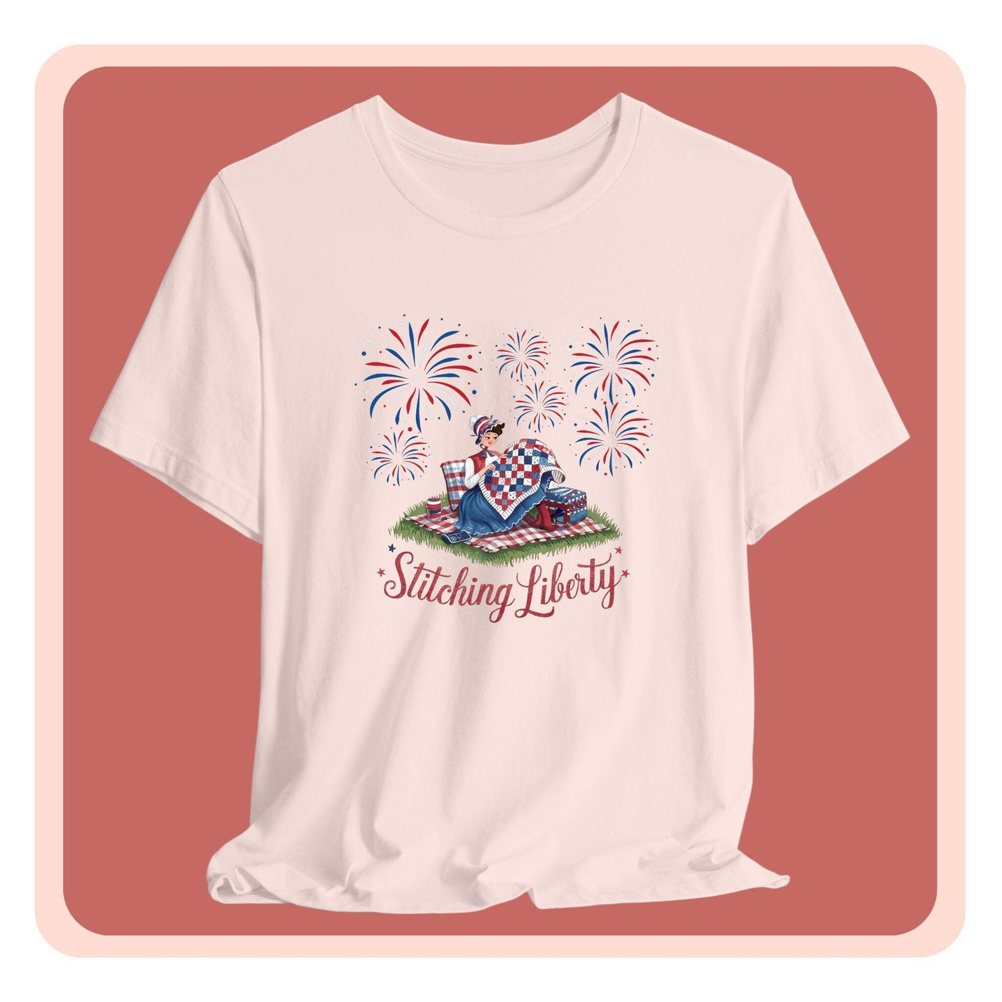 A T-shirt with illustrated scene of a colonial woman quilting a patriotic blanket, surrounded by fireworks. Text reads "Stitching Liberty" in a decorative font.