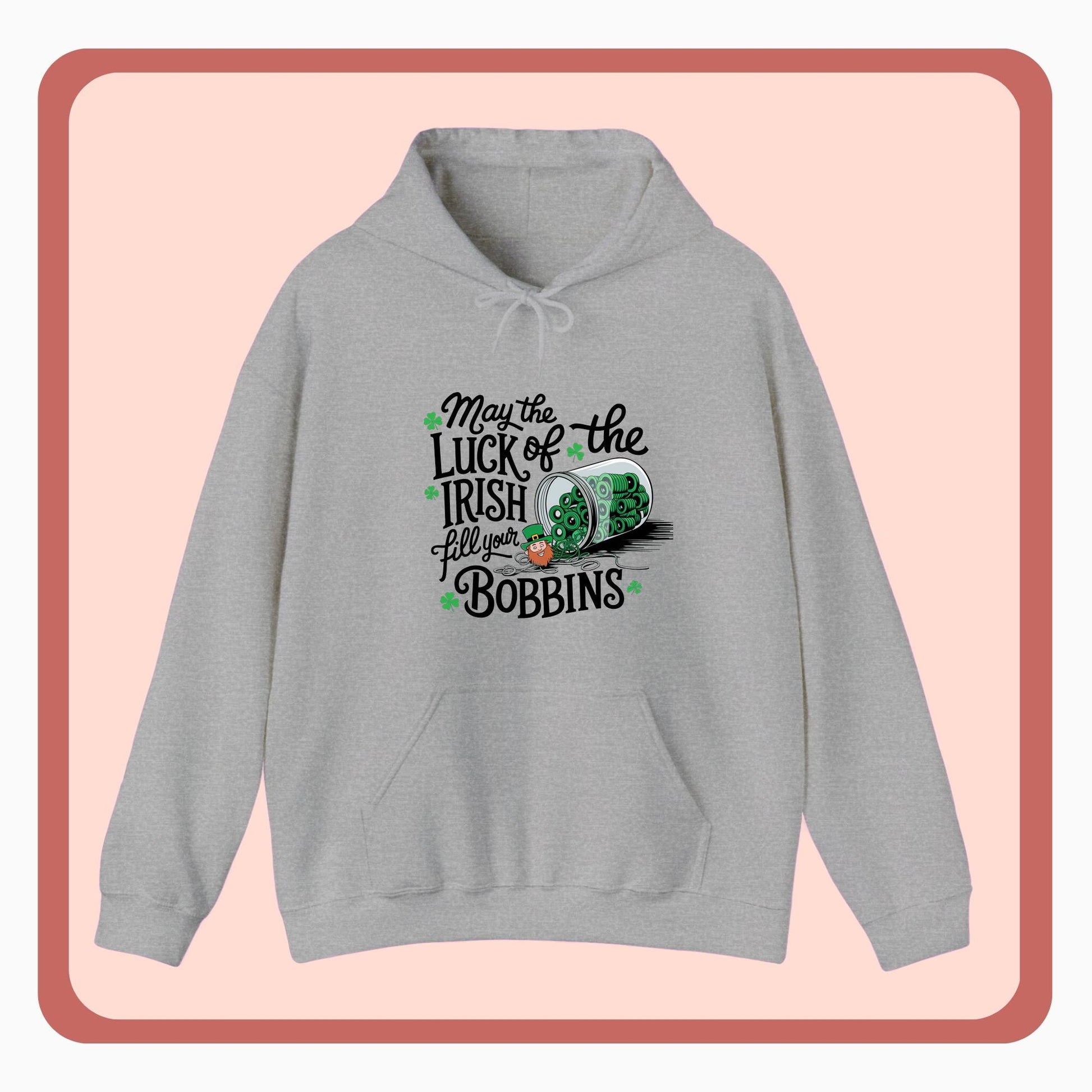 A hoodie featuring a festive design with shamrocks, a spool of green thread, and the phrase 'May the Luck of the Irish Fill Your Bobbins,' perfect for quilters celebrating St. Patrick’s Day.