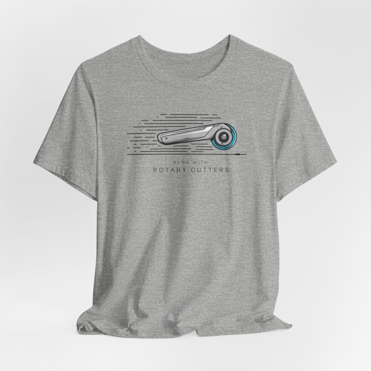 An Athletic Heather T-shirt featuring minimalist graphic of a sleek rotary cutter in motion with speed lines. Text below reads "RUNS WITH ROTARY CUTTERS" in a modern font.