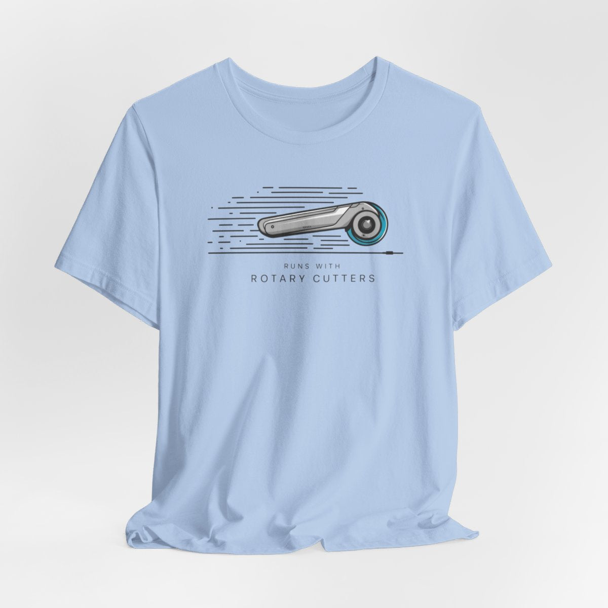 A Baby Blue T-shirt featuring minimalist graphic of a sleek rotary cutter in motion with speed lines. Text below reads "RUNS WITH ROTARY CUTTERS" in a modern font.