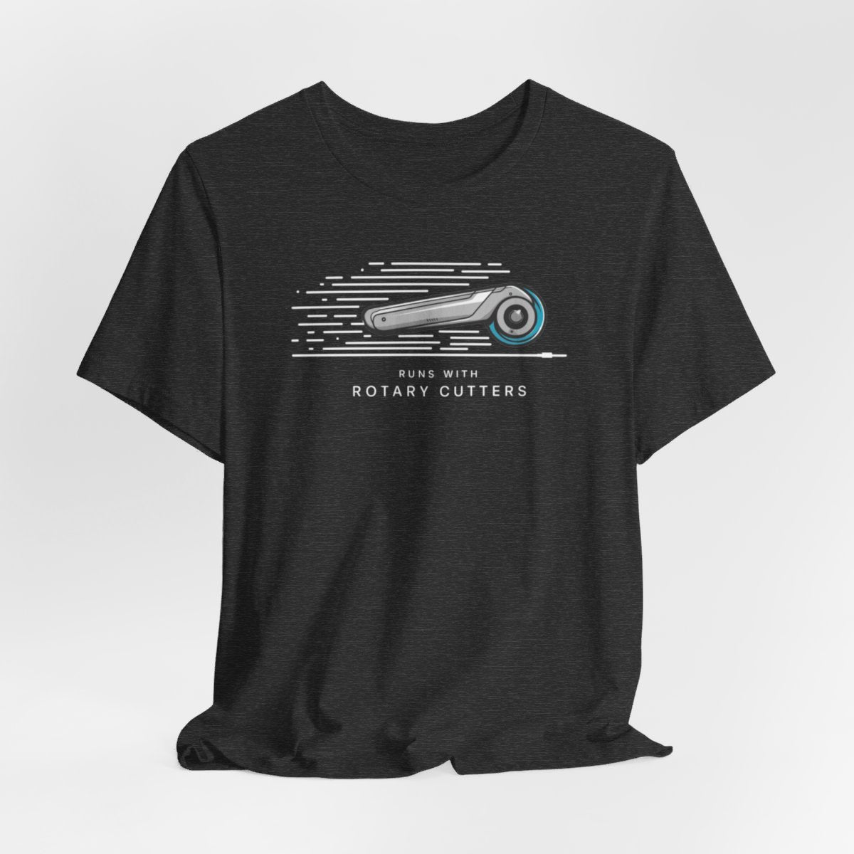 A Dark Grey Heather T-shirt featuring minimalist graphic of a sleek rotary cutter in motion with speed lines. Text below reads "RUNS WITH ROTARY CUTTERS" in a modern font.