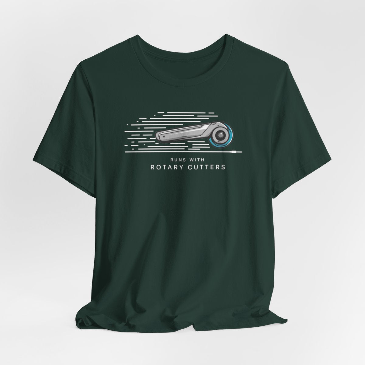 A Forest T-shirt featuring minimalist graphic of a sleek rotary cutter in motion with speed lines. Text below reads "RUNS WITH ROTARY CUTTERS" in a modern font.